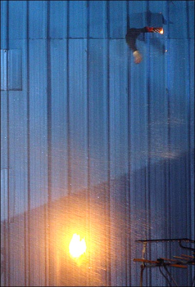 20일 새벽 서울 용산구 신용산역 부근 재개발 지역내 5층 건물 옥상에 가건물을 설치하고 농성중이던 철거민들이 경찰특공대를 향해 화염병을 던지고 있다.