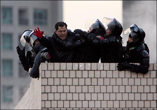 2009년 1월 20일 새벽 서울 용산구 신용산역 부근 재개발 지역내 5층 건물 옥상에서 철거민들이 농성을 벌이는 가운데 경찰특공대가 철거민들을 제압하고 있는 모습. 
