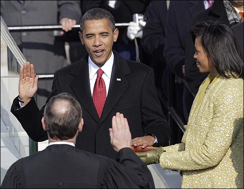 버락 오바마 제44대 미국 대통령이 20일 오전(현지시간) 워싱턴 국회의사당에서 열린 취임식에서 선서하고 있다. 오른쪽은 부인 미셸 오바마.