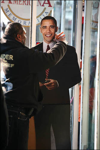 오바마의 실물 크기 사진을 세워놓고 사진을 찍고 있다.