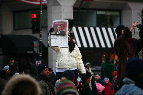 오바마의 사진이 실린 신문을 들고 한 여학생이 뭔가 외치고 있다.
