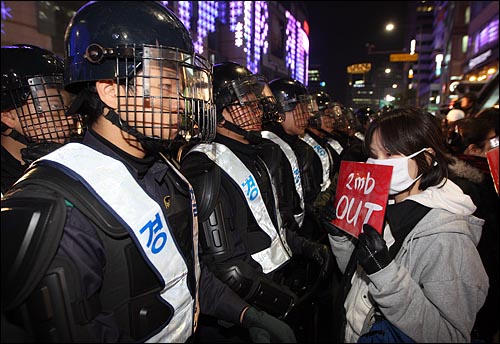 '용산철거민 살인진압 이명박 규탄 및 희생자 추모대회'를 마친 시민들이 21일 밤 서울 중구 명동 앞에 모여 경찰의 강제진압에 항의하며 손피켓을 들어보이고 있다.