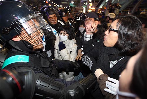 '용산철거민 살인진압 이명박 규탄 및 희생자 추모대회'를 마친 시민들이 21일 밤 서울 중구 명동 앞에 모여 경찰의 강제진압에 항의하며 대치를 하고 있다.