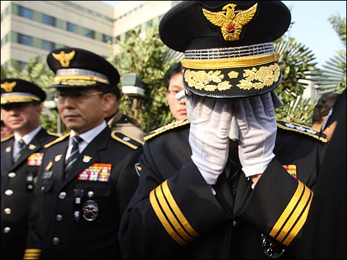 김석기 서울지방경찰청장이 운구행렬이 떠난 뒤 손수건으로 눈물을 닦고 있다.