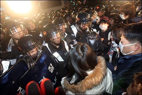 용산 철거민 참사가 발생한지 이틀이 지난 22일 저녁 서울 용산구 신용산역 부근 참사 현장에서 열린 '용산철거민 살인진압 이명박 규탄 및 희생자 추모대회'에서 시민들이 경찰의 강제진압에 항의하며 경찰들과 대치를 벌이고 있다.