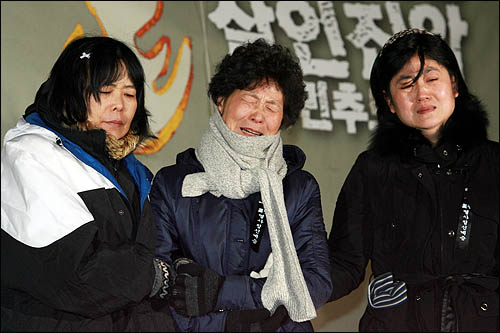 23일 저녁 서울역광장에서 열린 '용산 철거민 살인 진압 범국민 추모대회'에 함께한 희생자 유가족들이 슬픔을 삭이지 못한 채 눈물을 흘리고 있다.
