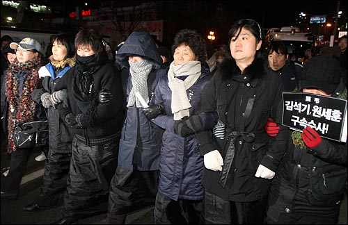 23일 밤 서울역 광장에서 열린 '용산 철거민 살인진압 범국민추모대회'에 참석했던 유가족들이 스크럼을 짜고 행진을 벌이고 있다.