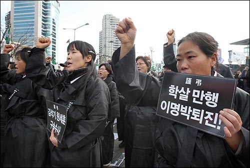  전국철거민연합, 전국노점상총연합 등 빈민단체 회원들이 31일 오후 서울역 광장에서 열린 '용산철거민 살인만행 이병박정권 퇴진, 빈민탄압중단, 민중생존권 쟁취 빈민대회'에서 상복을 입고 용산 철거민참사의 진상규명과 책임자 처벌을 요구하며 구호를 외치고 있다.