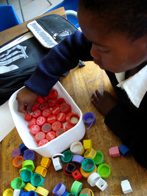 색깔별로 분류하는 놀이와 색이름에 해당하는 영어 단어와 문장을 연습하고 있는 남아공 카야만디의 이카야 초등학교 신입생 아봉길레