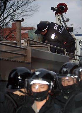 31일 저녁 서울 청계천로 한국관광공사 앞에서 열린 '용산 철거민 살인진압 희생자 제2차 범국민추모대회'에서 한 전경대원이 경찰 살수차에 파란색 색소를 붓고 있다.