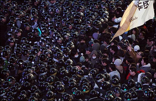 31일 밤 '용산 철거민 살인진압 희생자 제2차 범국민추모대회' 참석자들이 서울 명동 입구에서 도로를 점거한 채 구호를 외치자 경찰들이 시민들을 인도로 밀어올리고 있다.
