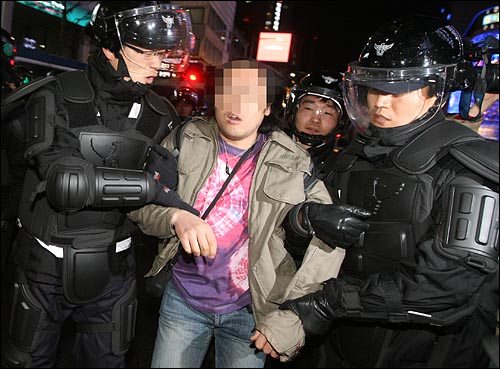 한 시민들이 31일 밤 서울 명동 입구에서 도로 점거시위를 벌이다 경찰에 연행되고 있다.