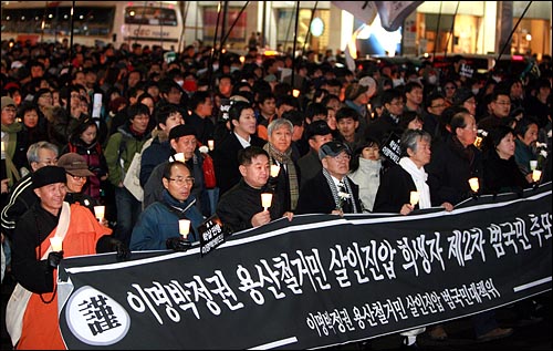 '용산 철거민 살인진압 희생자 제2차 범국민추모대회'에 참석했던 시민 수천명이 31일 밤 서울 명동 입구에서 행진을 벌이고 있다. 