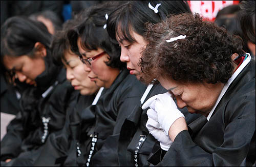 1일 오후 서울 청계광장에서 열린 '폭력살인진압 규탄 및 MB악법 저지를 위한 국민대회'에 참석한 용산철거민참사 희생자 유족들이 눈물을 훔치고 있다.