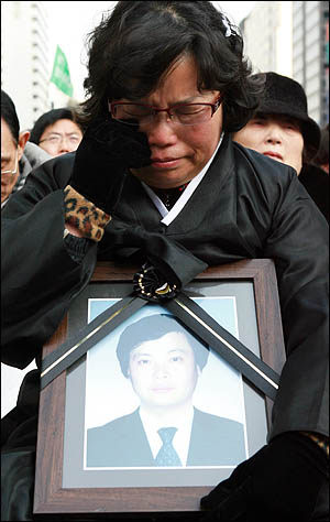 1일 오후 서울 청계광장에서 열린 '폭력살인진압 규탄 및 MB악법 저지를 위한 국민대회'에 참석한 용산철거민참사 희생자 유족들이 눈물을 훔치고 있다.