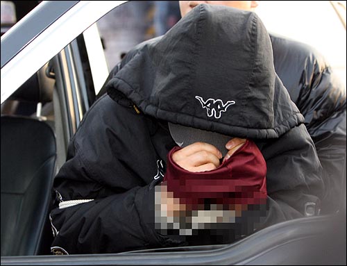 1일 오후 경기 서남부 연쇄살인범 강모씨가 경기도 화성시 신남동 버스정류장에서 부녀자를 유인하는 현장검증을 하는 가운데, 모자와 천으로 얼굴을 가리고 있다.
