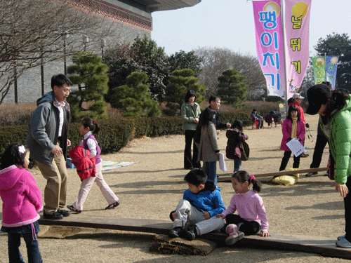  아이들과 함께 와서 널뛰기를 하고 있는 관람객.