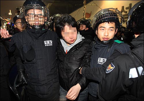 한 대학생이 6일 저녁 서울 중구 퇴계로 4가 앞에서 옷에 색소 분사기를 맞은 흔적이 있자 경찰들에게 강제연행 되고 있다.