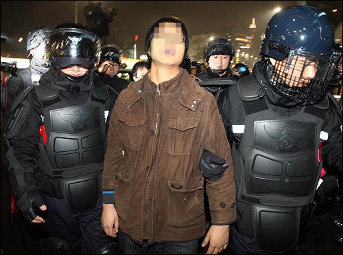 한 대학생이 6일 저녁 서울 중구 퇴계로 4가 앞에서 옷에 색소 분사기를 맞은 흔적이 있자 경찰들에게 강제연행 되고 있다.