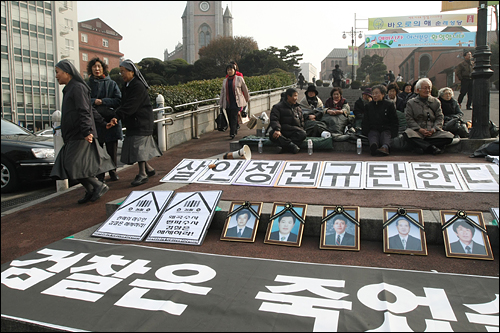  용산 철거민 참사에 대한 재수사를 요구하며 지난 11일 철야농성에 돌입한 '이명박 정권 용산 철거민 살인진압 범국민 대책위원회' 대표자들이 명동성당 계단에서 농성을 벌이고 있다.