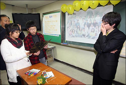 13일 오전 서울 송파구 거여동 거원초등학교에서 열린 졸업식에서 6학년 9반 학생들과 학부모들이 감사의 마음으로 박수영 교사에게 참스승님상을 주고 있다.