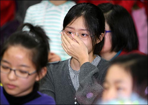  김윤주 교사와 노래를 함께 부르던 졸업생들이 눈물을 흘리고 있다.