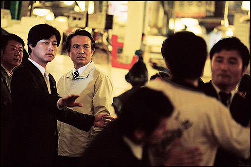  시장 상인들과 인사 하는 서울시장. 이 가운데 '똥투척 사건'이 일어나고, 이 사건으로 영화 속 서울시장의 이미지는 급격하게 실추된다. 
