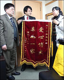 중국 여성이 남편의 시신을 거두어 준 것에 대한 감사의 뜻이 담긴 깃발을 들고 김해성 목사를 찾아왔다.