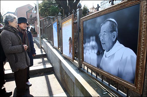 지난 16일 저녁 김수환 추기경이 선종한 가운데 17일 오전 서울 명동성당을 찾은 가톨릭 신자들이 전시된 김 추기경의 생전 사진을 둘러보고 있다.