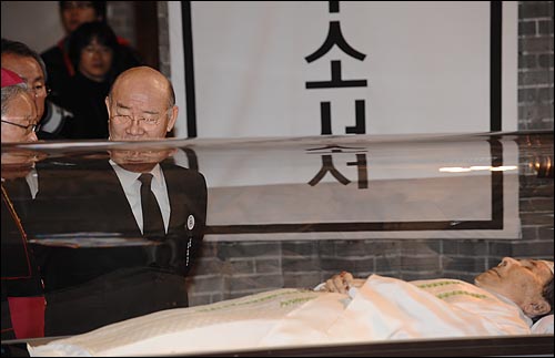'뒷짐'을 진 전두환 전 대통령이 고 김수환 추기경이 모셔진 유리관앞에 서 잇다.