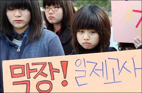 지난 23일 오전 서울시 교육청 앞에서 무한경쟁 일제고사에 반대하는 청소년, 청소년단체 활동가들이 농성돌입 기자회견 열고 일제고사 폐지와 일제고사로 인한 해직교사들의 복직을 요구하며 손피켓을 들어보이고 있다.