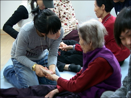 계룡시 생체협의 지도자가 요양중인 할머니의 손을 주무르며 말벗이 되어 주고 있다.