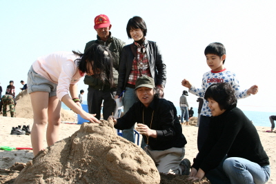 지난 1일 해운대 백사장에서 열린 모래조각 가족체험 교실에서 김길만(사진 가운데) 씨가 모래조각에 대해 설명하고 있다.  