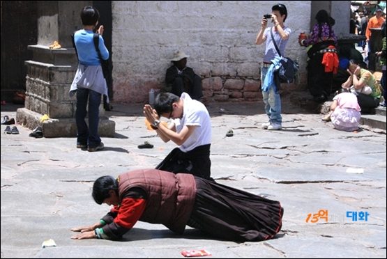 티베트 라싸의 조캉사원 앞. 오체투지하는 사람들과 여행객들의 사진촬영이 부조화를 이루며 살아가는 모습이다.