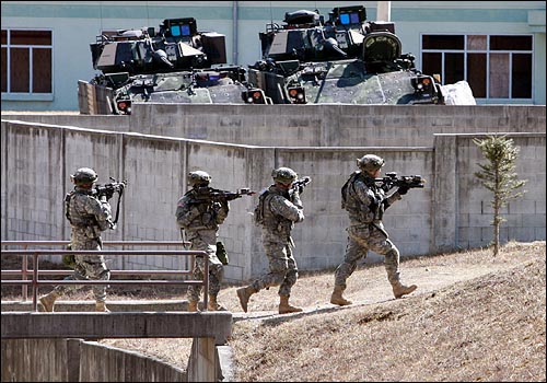 미 해병대가 장갑차 앞을 지나고 있다.