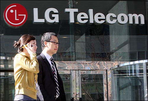 LG텔레콤에 입사한 새내기 김민주, 이동빈 직원이 6일 오후 서울 상암동 LG텔레콤 본사 앞에서 휴대전화를 하며 걸어가고 있다.