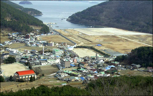  경남 마산시 구산면 수정마을 수정지구는 당초 주택용지로 매립되었다가 일반산업단지로 변경되었다. 사진에서 매립된 곳에 STX조선이 들어설 예정이며, 왼쪽에 보이는 집들이 수정마을이다.