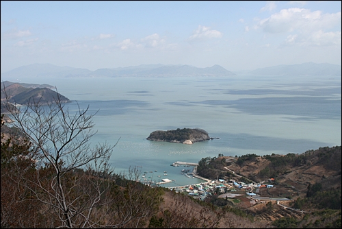  산길을 오르는 중에 보이는 바다풍경. 바다에는 구름이 검은 그림자가 되어 떠다니고 있다.