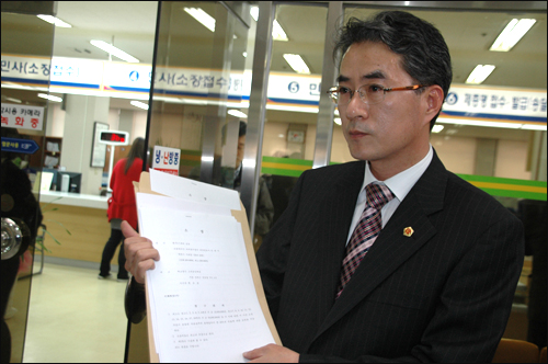 박종훈 전 경남도교육위원이 2009년 3월 17일 창원지법 접수과 앞에서 고려대를 상대로 한 집단소송 소장을 들어보이고 있다.