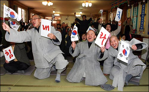  제2회 월드베이스볼클래식(WBC) 결승 한국-일본전이 열린 24일 오후 서울 견지동 조계사 극락전에서 응원전을 펼치던 스님과 신도들이 9회말 한국팀이 동점을 만들자 환호성을 지르며 기뻐하고 있다.