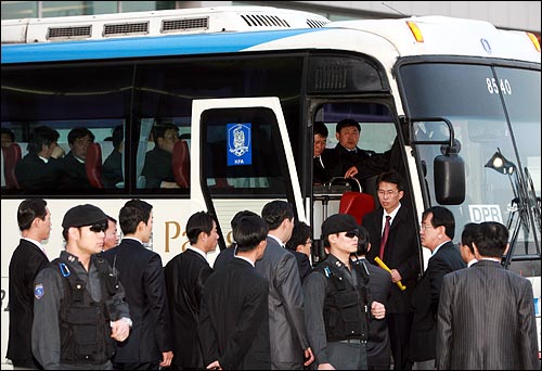 북한선수단이 공항경비대의 보호를 받으며 버스에 탑승하고 있다.