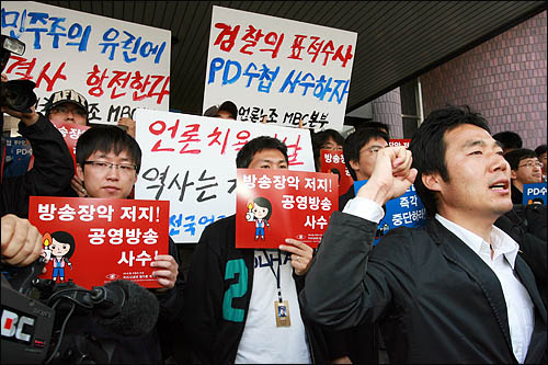 검찰이 'PD수첩'의 미국산 쇠고기 보도와 관련해 8일 오전 MBC본사 압수수색을 시도한 가운데, MBC 노조원들이 출입구를 봉쇄한 채 검찰 수사관들의 진입을 막고 있다.