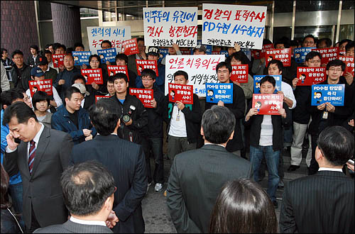검찰이 'PD수첩'의 미국산 쇠고기 보도와 관련해 지난 4월 8일 오전 MBC본사 압수수색을 시도한 가운데, MBC 노조원들이 출입구를 봉쇄한 채 검찰 수사관들의 진입을 막고 있다.