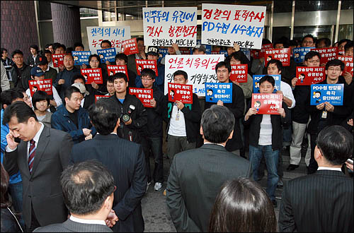  검찰이 'PD수첩'의 미국산 쇠고기 보도와 관련해 2009년 4월 MBC본사 압수수색을 시도한 가운데, MBC 노조원들이 출입구를 봉쇄한 채 검찰 수사관들의 진입을 막고 있다.