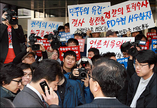 검찰이 'PD수첩'의 미국산 쇠고기 보도와 관련해 8일 오전 MBC본사 압수수색을 시도한 가운데, 출입구를 봉쇄한 MBC 노조원들과 검찰 수사관들이 대치하고 있다. 