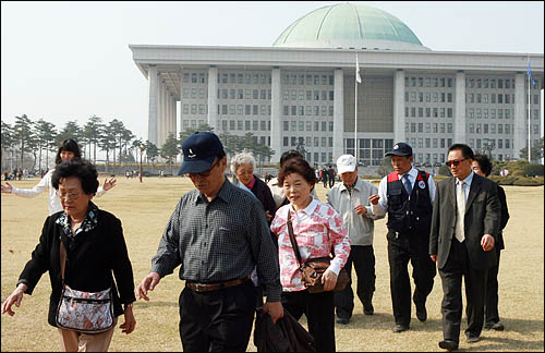  여의도 벚꽃축제 기간을 맞아 8일 국회를 찾은 상춘객들이 경내를 둘러보며 봄날을 만끽하고 있다.