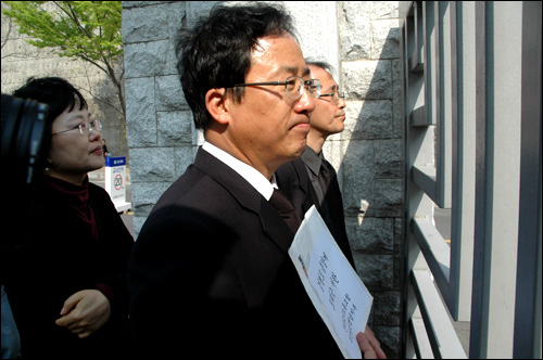 김석준 교수가 항의서한을 들고 닫혀 있는 창신대 정문 앞에 서 있다.