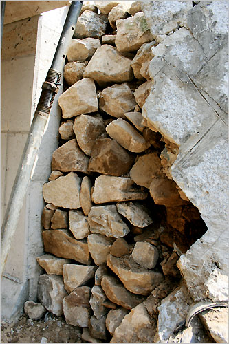 다리 제방에 쌓아 놓은 돌 더미에는 군데군데 폐콘크리트가 보인다.