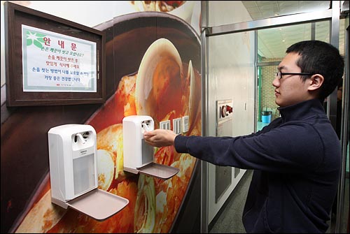 14일 오후 경기도 용인 한국외국어대학교 부속 외국어고등학교 식당에서 한 학생이 학교급식 위생과 안전을 위해 설치된 살균소독기를 사용하여 손을 씻고 있다.