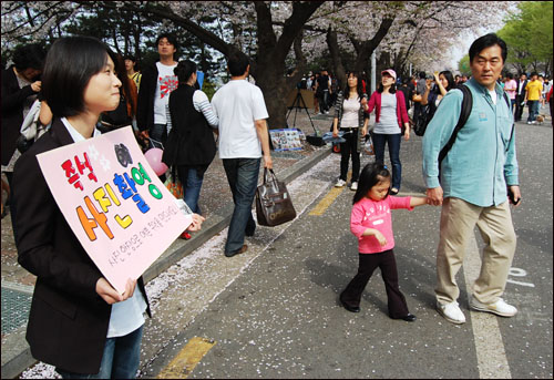 12일 벚꽃 축제가 열리는 여의도 윤중로에서 사진 촬영 홍보판을 들고 있는 이지수 기자.